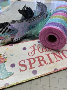 colorful spring ribbons with coordinating deco mesh and a cute hello spring wreath sign