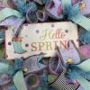 picture of a deco mesh wreath with spring sign and beautiful spring ribbons of teal, pink and purple