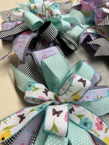 2 spring ribbon bows for a spring wreath of teal, purple and white with flowers