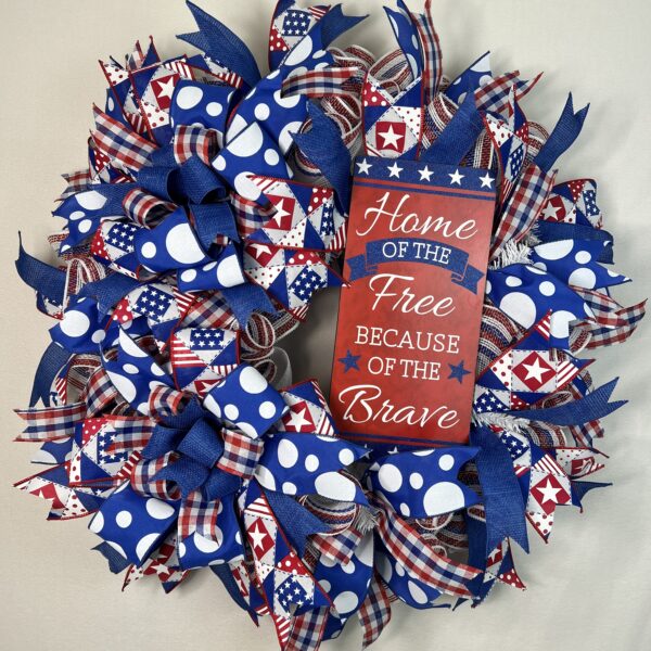 Patriotic wreath with lots of red, white and blue ribbons, polka dot ribbon and home of the free because of the brave sign with matching bow.