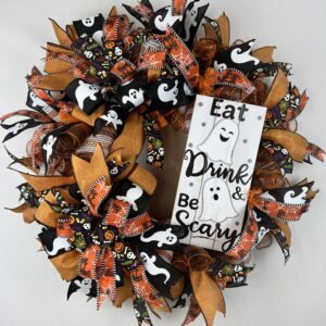 halloween wreath with a ghost sign reading Eat, drink and be scary, ghostly ribbons, orange and black with spider ribbons and black with skulls adorn this wreath, the base of this wreath is orange and white striped deco mesh and two big beautiful bows in the matching ribbons are attached.