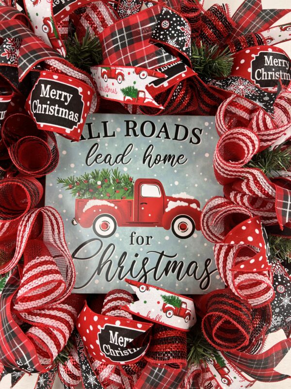 Christmas wreath with All roads lead to home sign, ribbons and a big bow of red plaid, snowflakes, and merry Christmas, a deco mesh base of red and white compliment the wreath