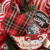 Christmas wreath with All roads lead to home sign, ribbons and a big bow of red plaid, snowflakes, and merry Christmas, a deco mesh base of red and white compliment the wreath