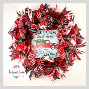 christmas holiday wreath with all roads lead home for christmas sign, sign ahs red truck with christmas tree in the back, red plaid ribbons, merry christmas ribbon, snowflake ribbon, red truck ribbons, red and white border deco mesh is the base, a bow adorns the wreath in matching ribbons