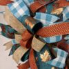 Sunflower fall wreath with teal sunflower sign, rus, gold, bronze and teal plaid ribbons adorn thewreath, matching ribbon bows adorn this wreath, on a base of rust and teal deco mesh