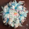 bunny deco mesh wreath, carrot patch bunny sign with coordinating colored ribbons, one boy at bottom on wreath under sign on teal white and pink plaid deco mesh
