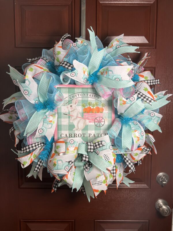 bunny deco mesh wreath, carrot patch bunny sign with coordinating colored ribbons, one boy at bottom on wreath under sign on teal white and pink plaid deco mesh