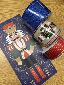 elements to make a christmas wreath, nutcracker sign, and 3 coordinating ribbons of red and gold, nutcrackers, glitter blue to match sign