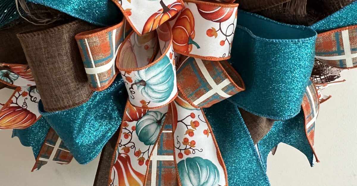 fall wreath with Hey there Pumkin sign, teal and brown plaid ribbon, pumpkin ribbons, brown and teal deco mesh base, matching bow