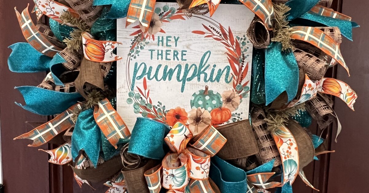 fall wreath with Hey there Pumkin sign, teal and brown plaid ribbon, pumpkin ribbons, brown and teal deco mesh base, matching bow