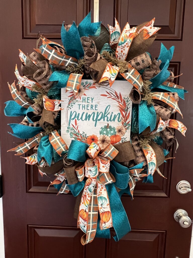 fall wreath with Hey there Pumkin sign, teal and brown plaid ribbon, pumpkin ribbons, brown and teal deco mesh base, matching bow