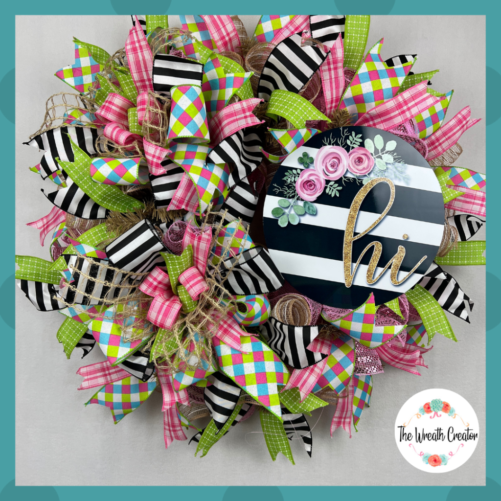 Year round decomesh wreath with Hi sign and coordinating elements like deco mesh ribbons and sign, colors of pinks, greens and whimsical black and white stripes