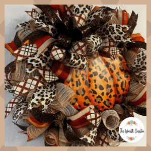 Fall wreath with metal pumkin sign and leopard and plaid ribbons and bows